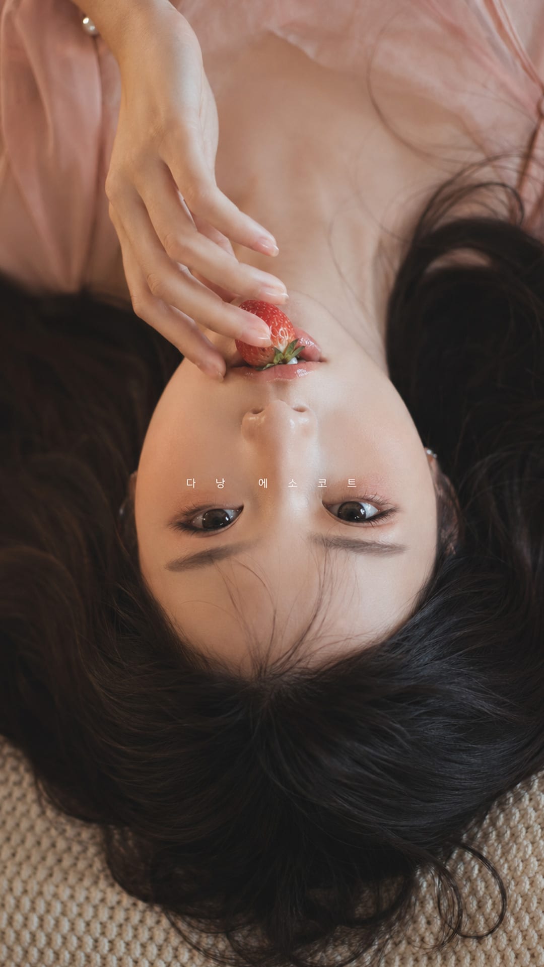누워서 딸기를 먹고 있는 여자의 모습